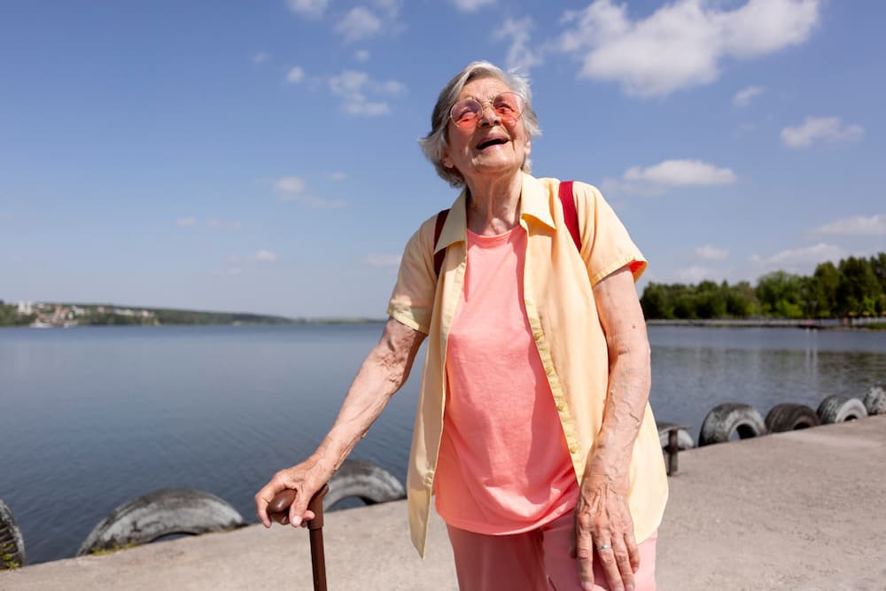 Mujer mayor disfrutando de paseo bajo el sol