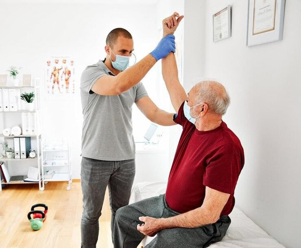 Adulto mayor recibiendo fisioterapia a domicilio