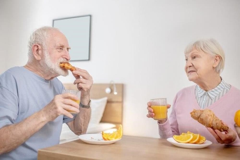 Adultos mayores desayunando en residencia temporal durante respiro familiar