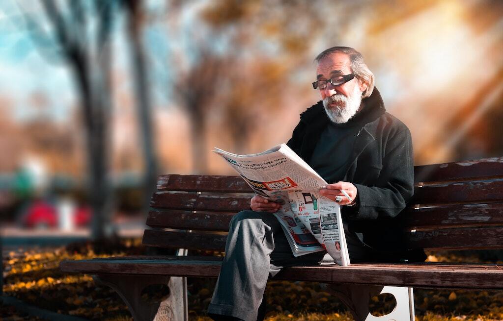 hombre mayor leyendo un libro sobre los beneficios de la lectura en personas mayores