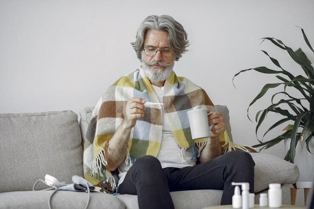 Hombre mayor afrontando los síntomas de la gripe o el resfriado