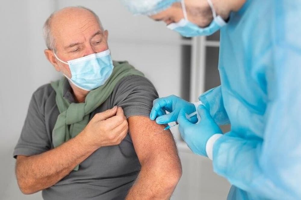 Persona mayor recibiendo vacuna de la gripe