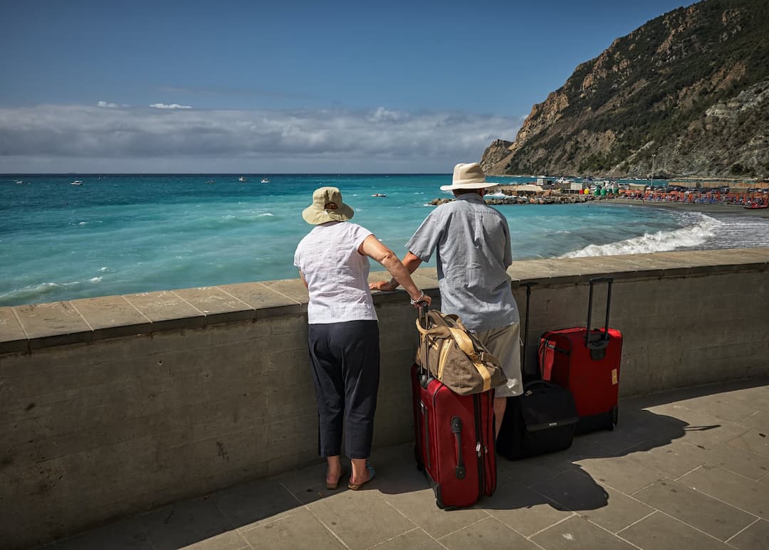 dos personas mayores contemplando el paisaje de playa
